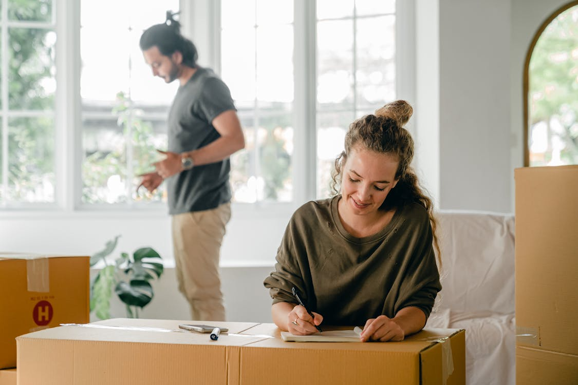 a woman happily writing in a notepad.